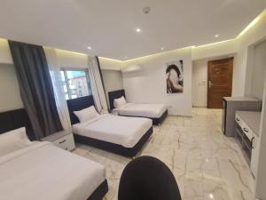 a hotel room with two beds and a desk at Boutique Hotel El Mesaadia in Cairo
