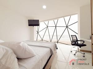 a bedroom with a bed and a chair and a window at Beachfront Escape Pool Hot Tub and Fire pit in Montañita