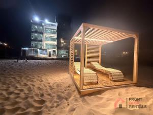 a wooden structure sitting on the beach at night at Beachfront Escape Pool Hot Tub and Fire pit in Montañita +32 photos