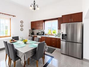 a kitchen with a table and a stainless steel refrigerator at Luxury Villa Ntina in Maronia