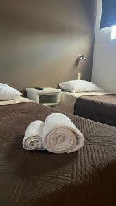 a hotel room with two beds with towels on the bed at Casa UNO in San Rafael