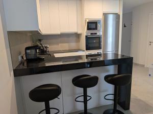 a kitchen with black counter tops and stools at Jardín del Jiloca in Calamocha