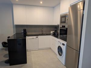 a kitchen with a refrigerator and a washer and dryer at Jardín del Jiloca in Calamocha