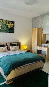 a bedroom with a large bed with a green blanket at Ulcinj apartments in Ulcinj
