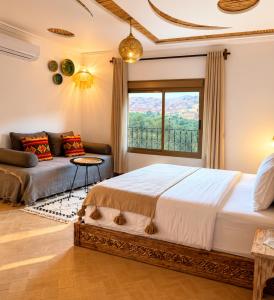 a bedroom with a bed and a couch and a window at Dar Rihana Dadès in Aït Idaïr +29 photos