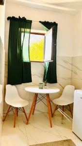 a table and chairs in a room with a window at Ulcinj apartments in Ulcinj +13 photos