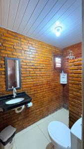 a bathroom with a brick wall with a sink and a toilet at Pousada Recanto das Fontes in Beberibe +37 photos