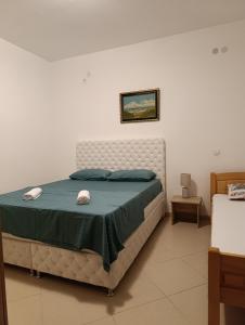 a bedroom with a large bed with a green blanket at Lustica-Apartment Dora3 in Herceg-Novi
