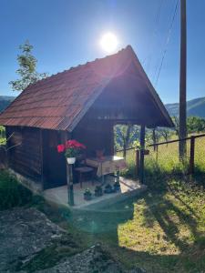 a small hut with a table and flowers on it at Etno kuća Močioci in Ivanjica