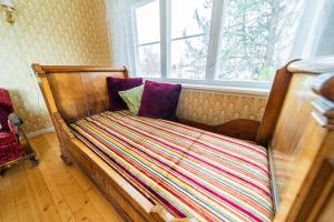 a wooden bed in a room with a window at Snertingdal ysteri in Gjøvik