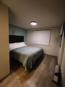 a bedroom with a bed and a projection screen at Departamento El refugio in Osorno +4 photos