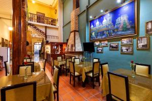 a dining room with tables and chairs in a restaurant at Hotel Majestic 1 Centro Histórico Cuenca in Cuenca