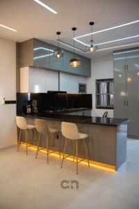 a kitchen with a counter and chairs in a room at Villa CICAS in Cotonou