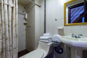 a bathroom with a sink and a toilet and a mirror at Hotel Majestic 1 Centro Histórico Cuenca in Cuenca +41 photos