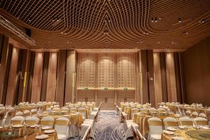 a banquet hall with tables and chairs in front of a window at Hanna Seaview Stella - The Arena Resort in Cam Ranh International Airport +153 photos