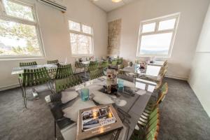 a room with tables and green chairs and windows at Snertingdal ysteri in Gjøvik +14 photos