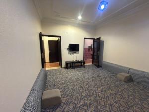 a waiting room with a couch and a tv at مساكن المبيت 5 new in Abha