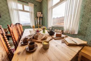 a wooden table in a dining room with a window at Snertingdal ysteri in Gjøvik