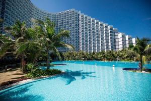 a resort with a large swimming pool in front of a building at Hanna Seaview Stella - The Arena Resort in Cam Ranh International Airport