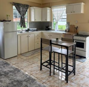 a kitchen with white appliances and a table in it at Hibiscus Apt 1 in Corinthe