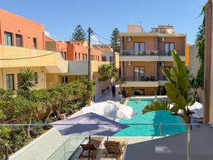 a hotel with a swimming pool and a building at Ariadne Beach in Platanias