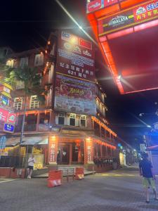a building with signs on the side of it at night at Nangyang lodge in Malacca +6 photos