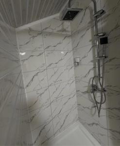 a bathroom with a shower with white marble walls at Filip in Sarajevo +22 photos