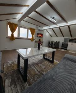 a living room with a table and a kitchen at Filip in Sarajevo