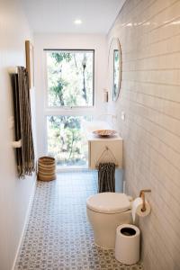 a bathroom with a toilet and a window at ROSINA Beach Shack in Bellbrae +32 photos