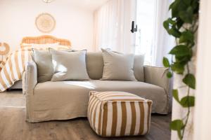 a couch sitting in a living room next to a window at ROSINA Beach Shack in Bellbrae