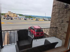 a balcony with a red car parked on a street at Martin's apartment in Saguenay