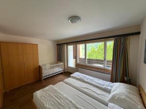 a bedroom with two beds and a large window at Schlossli-Le Petit Chateau in Leukerbad +69 photos