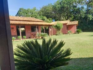 a house with a palm tree in the yard at Pousada Recanto do Sossego- Serra da Canastra in Vargem Bonita