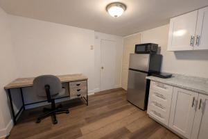 a kitchen with a desk and a chair and a refrigerator at Countryside studio on a lake in Bic