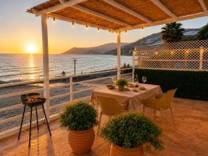 a table on a balcony with a view of the ocean at Cala Vemar - 2 Mediterranean Beach Houses in Haza del Trigo