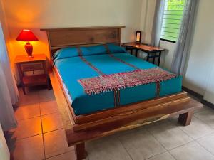 a bedroom with a bed with a blue comforter at Kliffstone Jungle House in Sayab Camp
