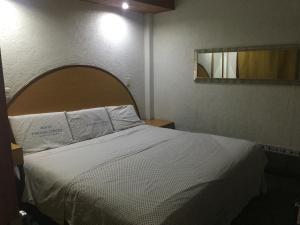 A bed or beds in a room at Hotel Paraiso Express