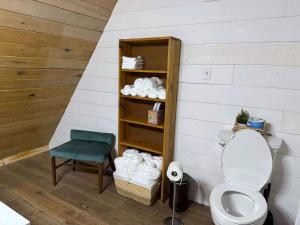 a bathroom with a toilet and a chair and towels at Tall Timber in Packwood +24 photos
