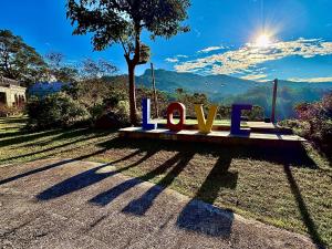 a bench with the word love sitting in the grass at Fong Chou Chalet in Sanyi