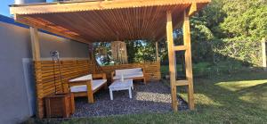 a wooden pergola with a table and chairs under it at Lamerced in Mar de Cobo +20 photos
