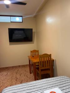 a room with a table and two chairs and a television at casa sol de sauce in Sauce