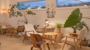 a waiting room with chairs and tables and plants at Yangyang Stay Wabom in Yangyang +6 photos