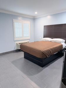 a bedroom with a bed in a room with a window at Coronado Motel in Long Beach