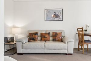a white couch in a living room with a table at Modern-Immaculate-Spacious-Comfy Beds-Private in Westport