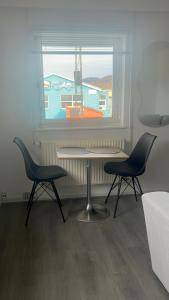 a table and two chairs in front of a window at Ilulissat City Apartments- Apartment 2 in Ilulissat