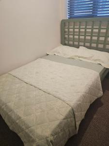 a bed in a white room with a window at Mini studio apartment in Tulla
