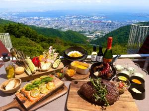 a table with plates of food and bottles of wine at Nature Live Rokko in Kobe