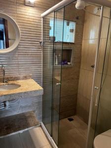 a bathroom with a glass shower and a sink at G2 Hospedagem Suites & Studio Praia Dos Anjos in Arraial do Cabo +19 photos