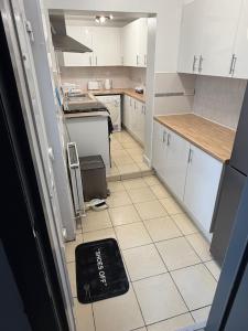 a kitchen with white cabinets and a black rug on the floor at GS Maisons Hideaway in Sheffield +13 photos