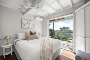 a bedroom with a bed and a large window at Misty Valley Cottage in Mapleton